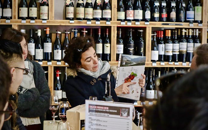 Bar tender showing tour group a map of Lisbon wineries during a food tour.
