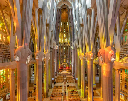 Sagrada Familia interior with towering columns and colorful stained glass windows.
