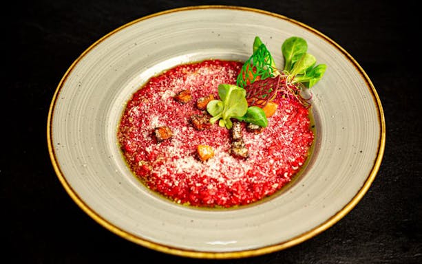 Beetroot risotto garnished with greens on Budapest dinner cruise.