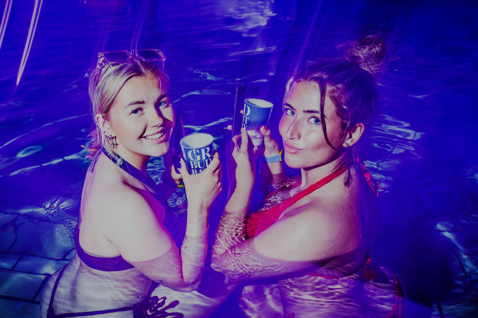 Nighttime pool party at Széchenyi Thermal Bath, Budapest, with vibrant lights and lively crowd.