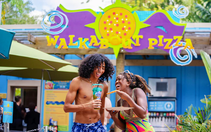 Couple enjoying pizza at Walkabout Pizza in Aquatica Orlando.
