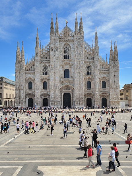 Guided tour group exploring Milan Cathedral facade.