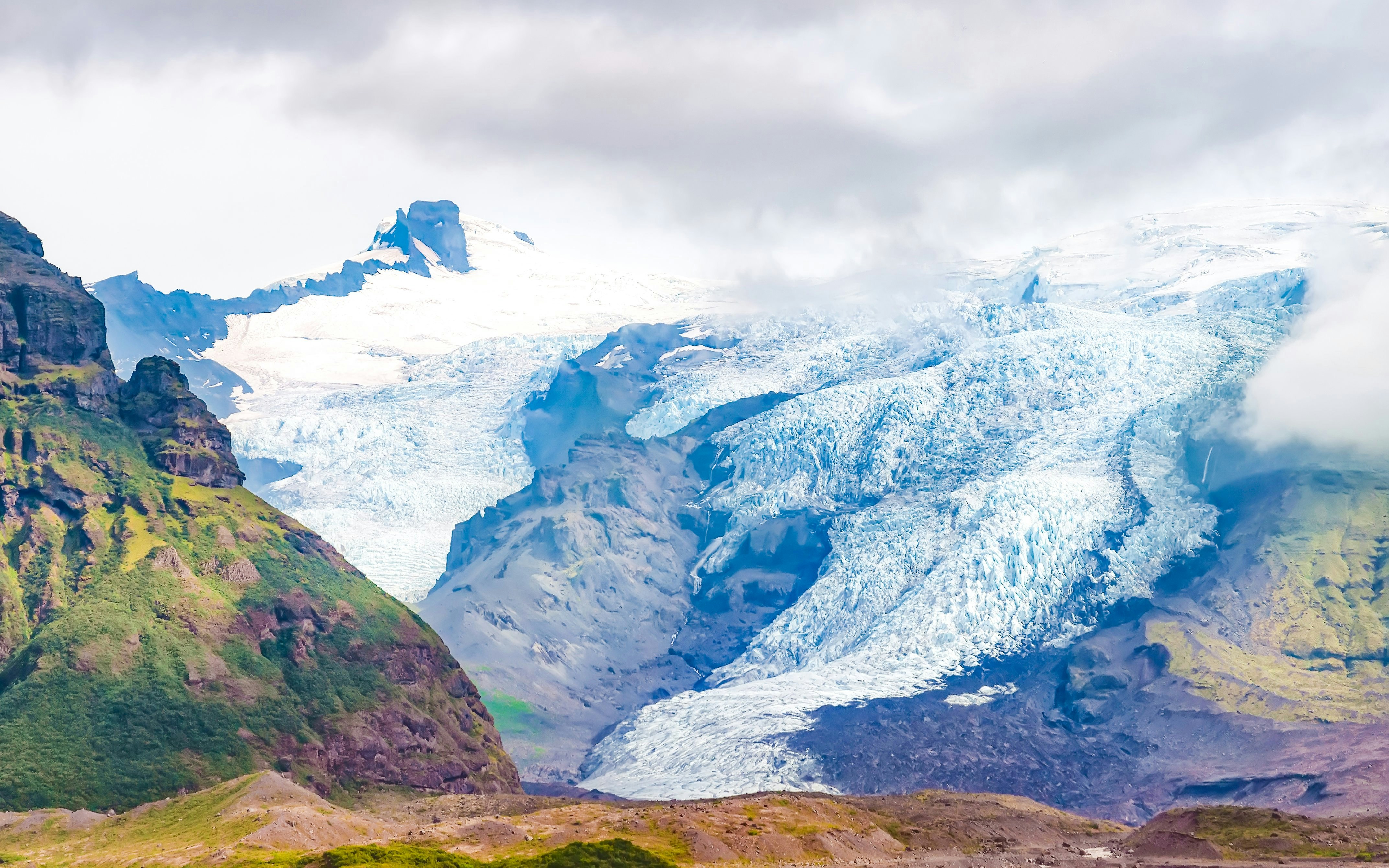 Falljokull Glacier tongue with rugged mountain landscape in Iceland.