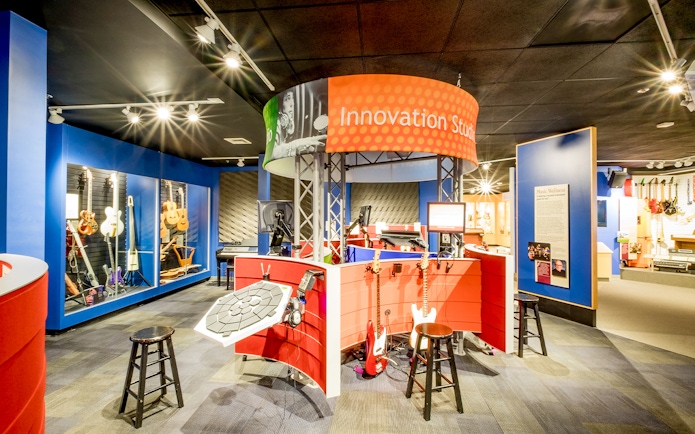 Innovation Studio with guitars and music equipment display in San Diego museum.