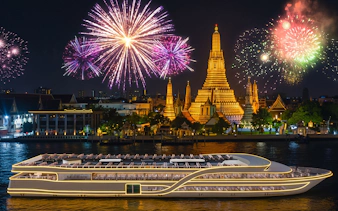 Cruise ship on Chao Phraya River with Wat Arun and fireworks, Bangkok.