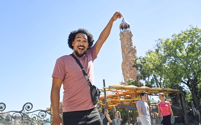 Man posing with Islands of Adventure tower at Universal Studios Orlando.