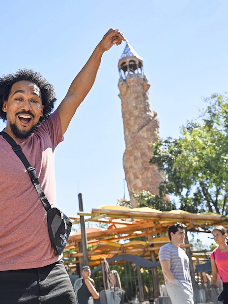 Man posing with Islands of Adventure tower at Universal Studios Orlando.