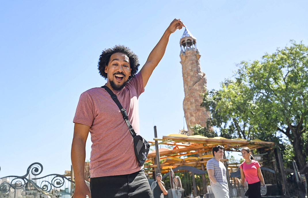 Man posing with the Islands of Adventure tower at Universal Studios Resort in Orlando