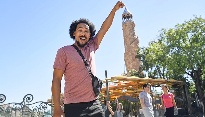 Man posing with Islands of Adventure tower at Universal Studios Orlando.