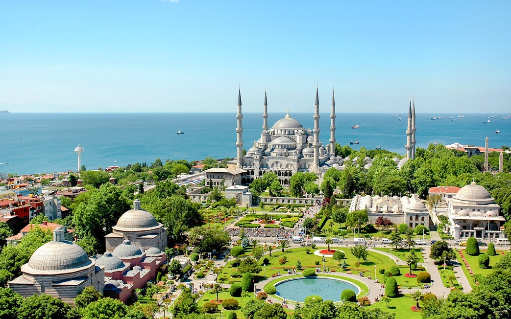 Blue Mosque exterior with gardens and view of the Bosphorus in Istanbul.