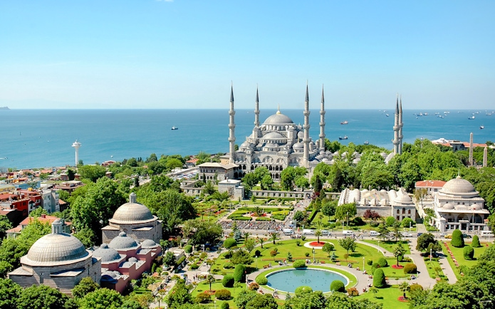 Blue Mosque exterior with gardens and view of the Bosphorus in Istanbul.