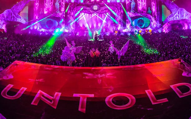 Crowd at UNTOLD Music Festival Dubai with vibrant stage lights and decorations.