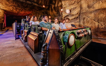 Visitors enjoying the Uncharted ride at PortAventura in a cave-themed setting.