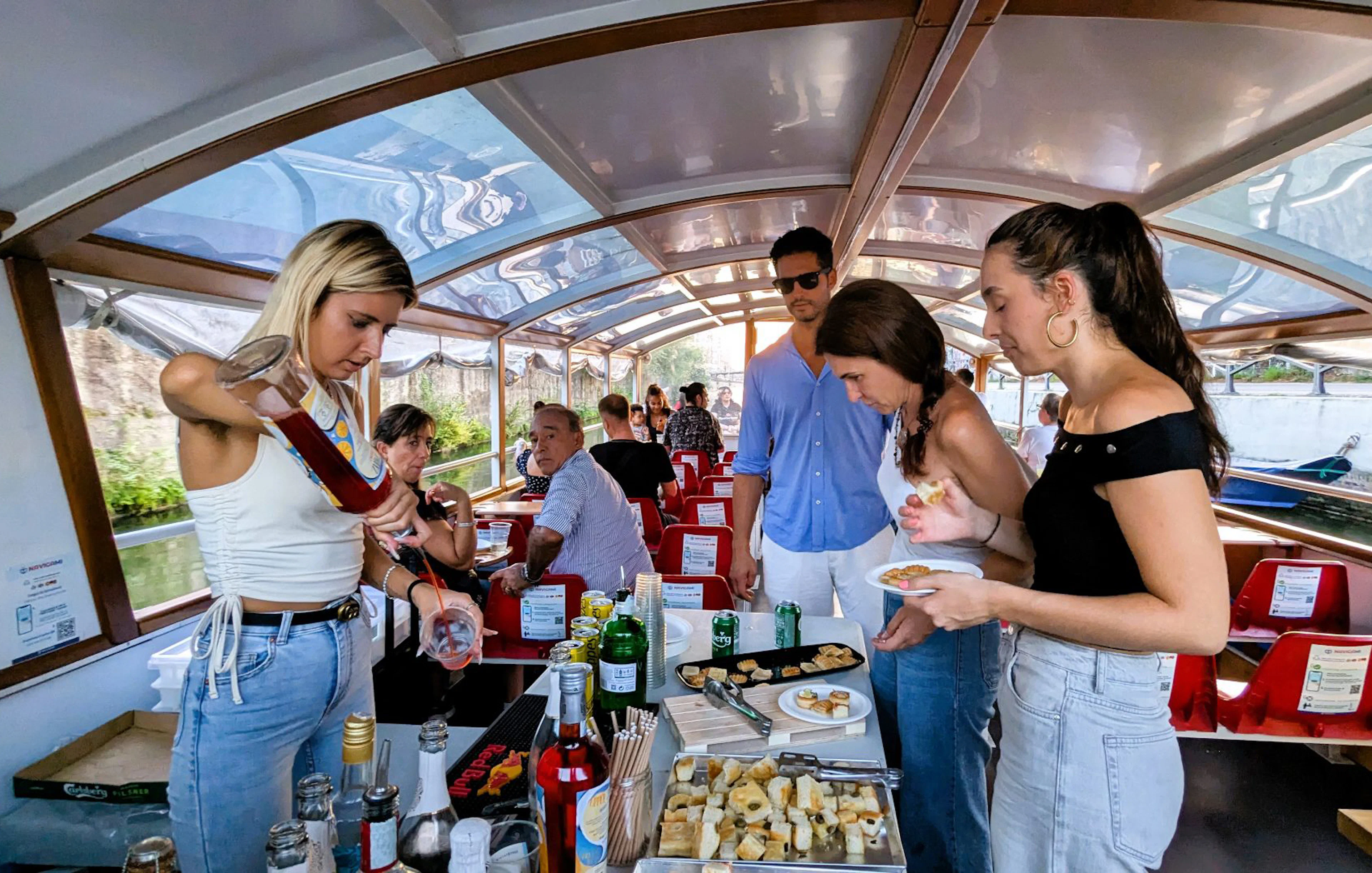 Aperitif drinks and snacks served on a Navigli canal cruise in Milan.