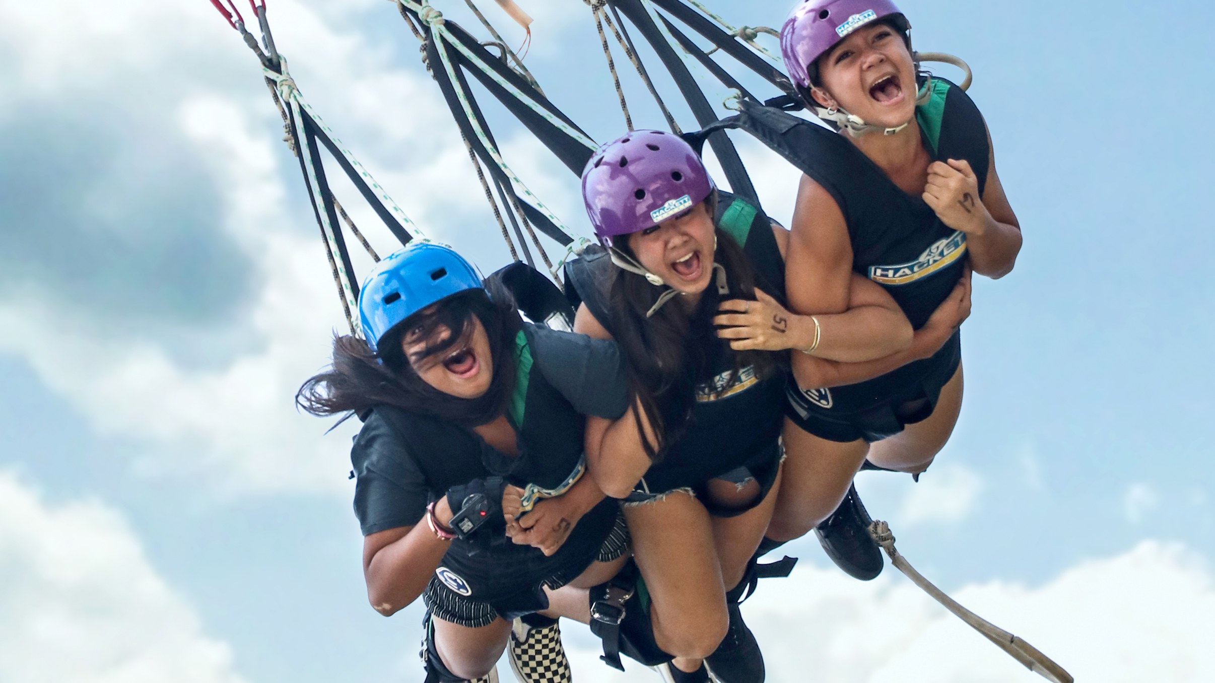 Friends enjoying a tandem swing at Skypark Sentosa by AJ Hackett.