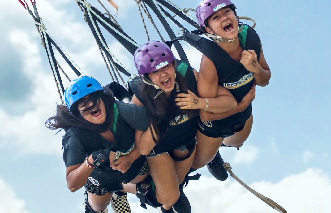 Friends enjoying a tandem swing at Skypark Sentosa by AJ Hackett.