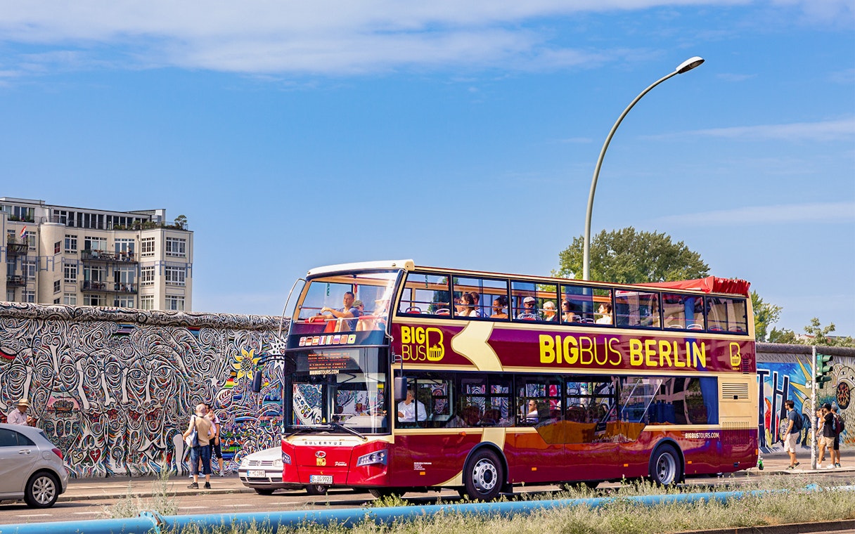 Big Bus Berlin tour passing East Side Gallery murals.
