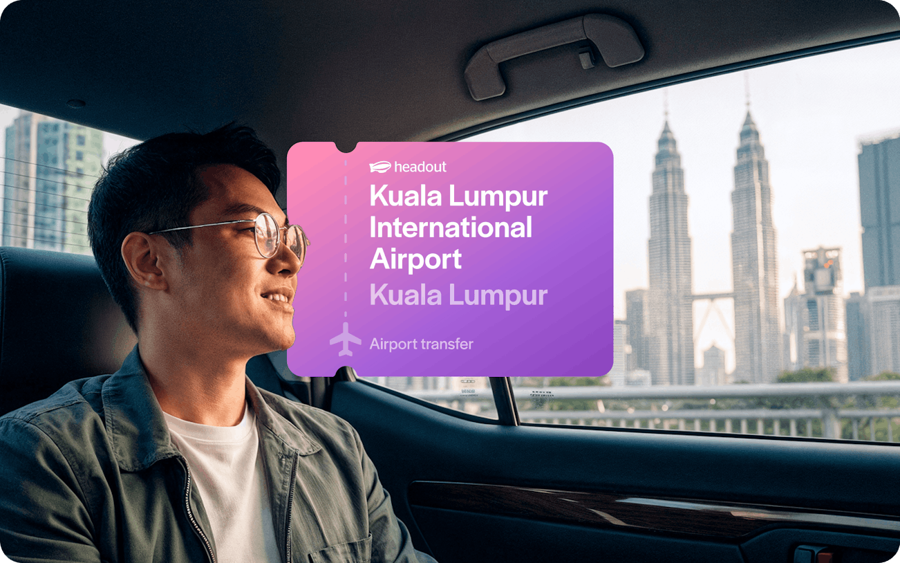 Man in car with view of Petronas Towers, Kuala Lumpur airport transfer.