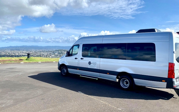 Transfer van parked with Auckland cityscape in the background, en route to Hobbiton Movie Set.