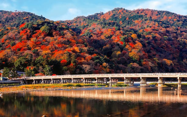 Togetsukyo Bridge with autumn foliage in Arashiyama, Kyoto, Japan.