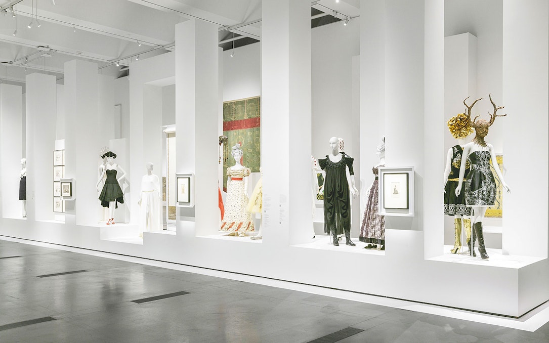 Alexander McQueen exhibition with mannequins in avant-garde fashion at a museum.