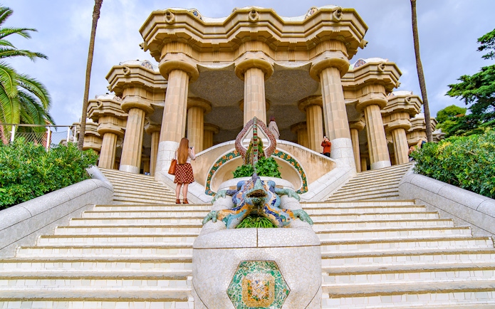 Tourist at the dragon staircase of Park Güell, Barcelona.