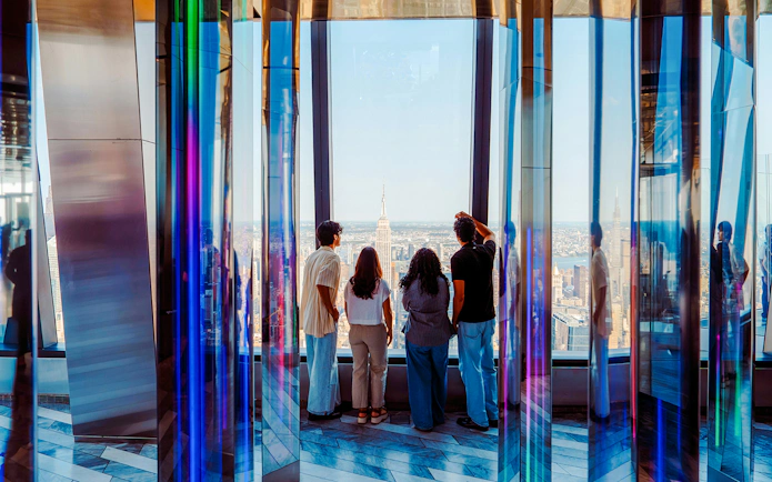 Visitors enjoying the view from Edge NYC Observation Deck with Empire State Building in sight.