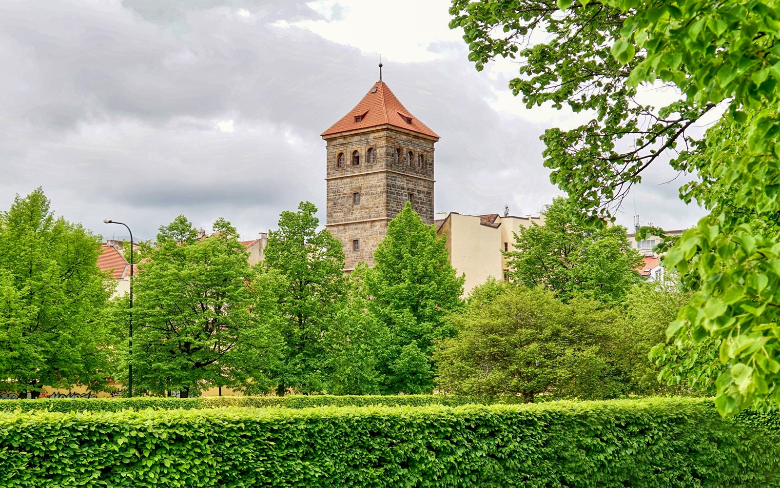 New Mill Water Tower in Prague surrounded by lush green trees.