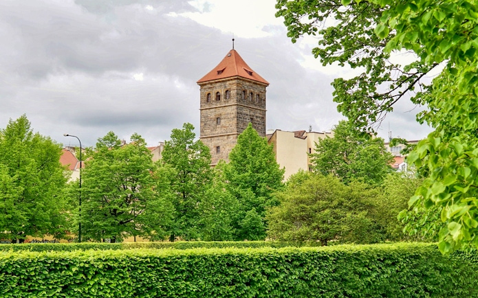 New Mill Water Tower in Prague surrounded by lush green trees.