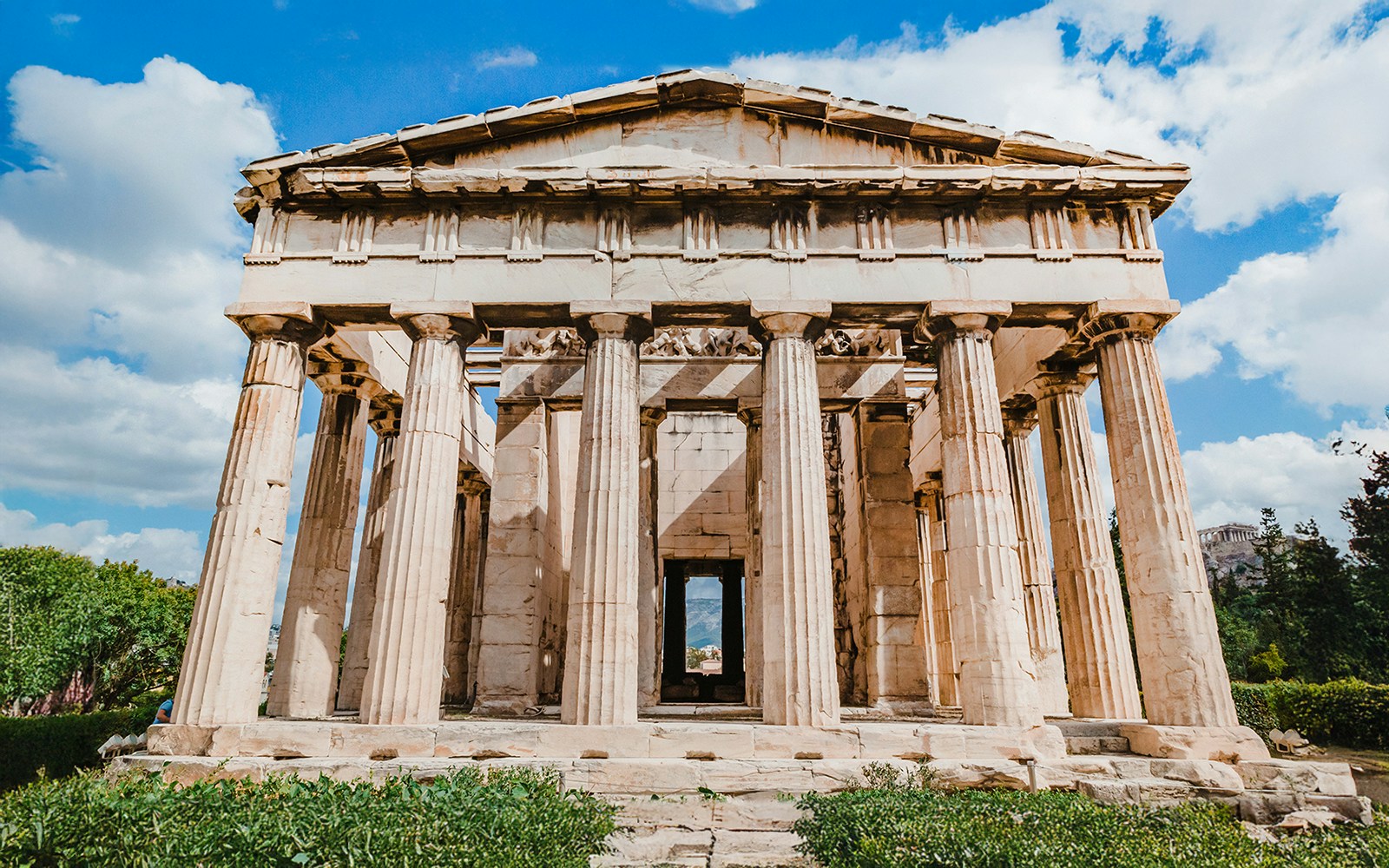 Temple of Hephaestus with Doric columns in Agora, Athens under blue sky.