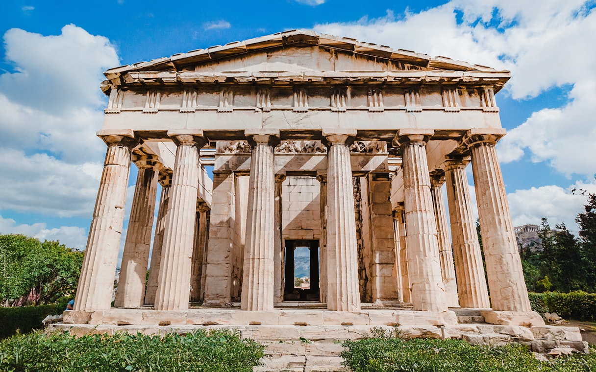 Temple of Hephaestus with Doric columns in Agora, Athens under blue sky.