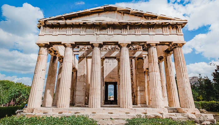 Temple of Hephaestus with Doric columns in Agora, Athens under blue sky.