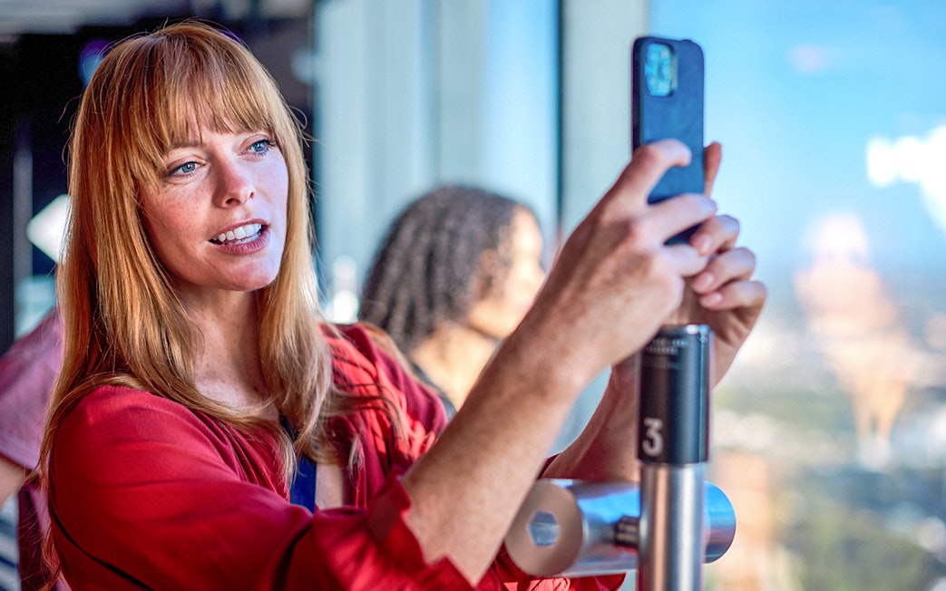 Person taking a photo at Melbourne Skydeck during Cocktails in the Clouds Experience.