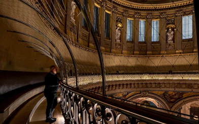 Interior view of St Paul's Cathedral dome with visitor on the Whispering Gallery.