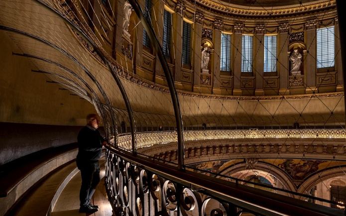 Interior view of St Paul's Cathedral dome with visitor on the Whispering Gallery.