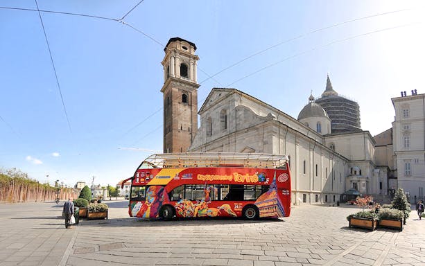 Turin sightseeing bus near historic cathedral in city center.