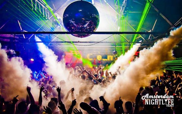 Crowd enjoying a vibrant nightclub with lasers and smoke in Amsterdam.