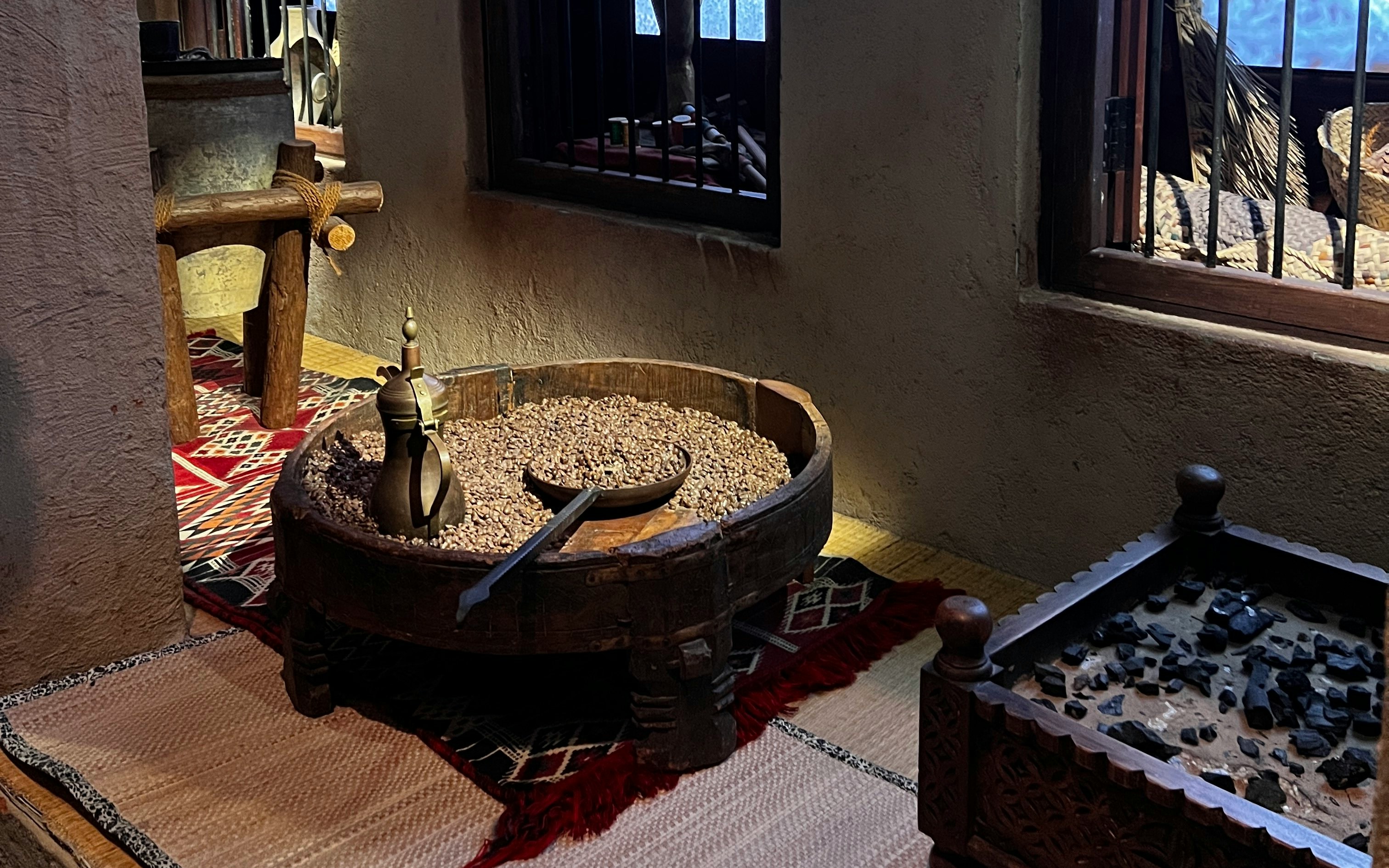 Traditional coffee preparation setup in Old Dubai Gallery, featuring a brass pot and coffee beans.