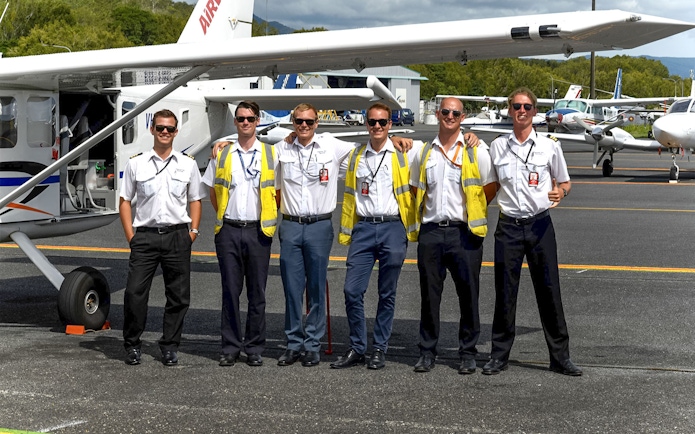 Pilots standing together on the tarmac at Cairns Airport.