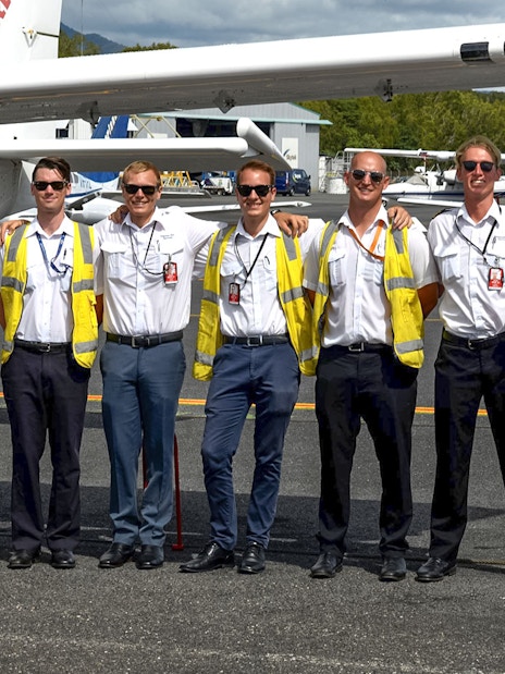 Pilots standing together on the tarmac at Cairns Airport.