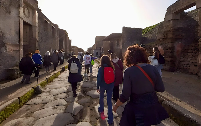 Tourists walking through ancient streets of Pompeii, Italy.