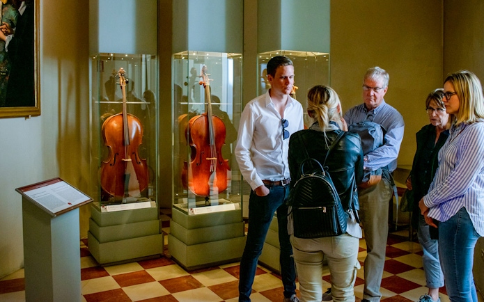 Tourists viewing cellos in Gallerie dell'Accademia, Venice.