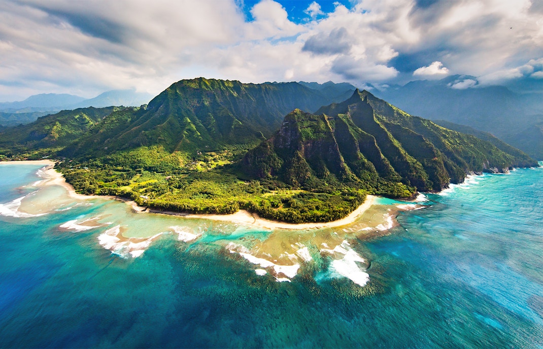 Na Pali Coast cliffs and ocean view in Hawaii, showcasing rugged terrain and lush greenery.