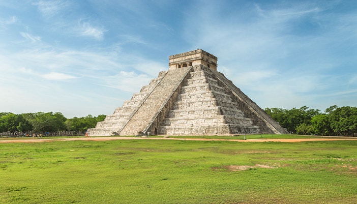Pyramid of Kukulcan at Chichen Itza, Mexico, under a clear blue sky.