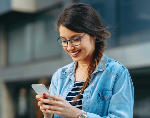 Woman smiling while reading a message on the phone