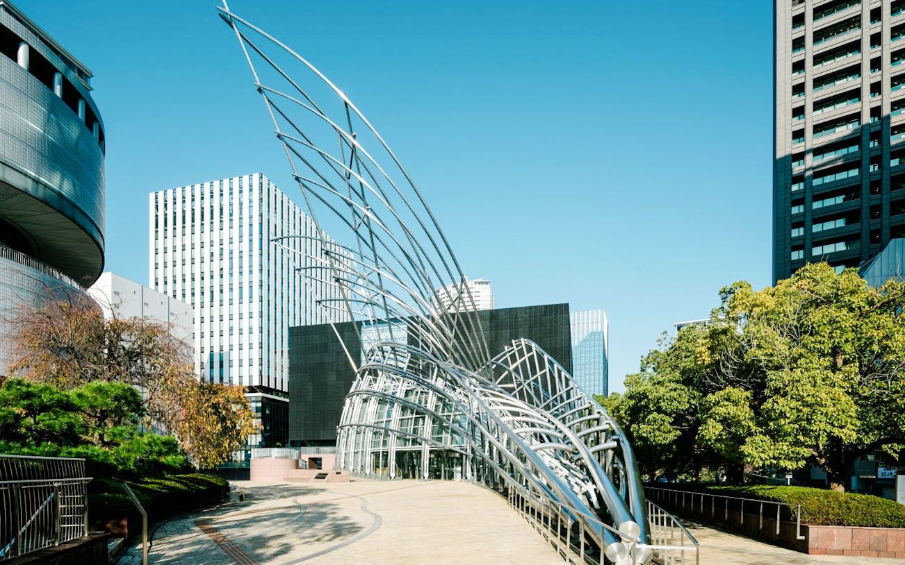 Sculptural entrance of The National Museum of Art, Osaka, with city buildings in the background.