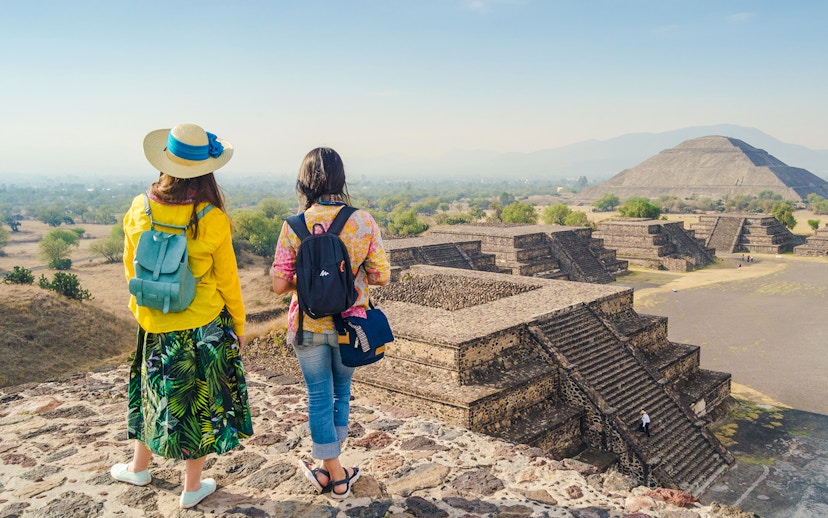 Two tourists overlooking the Teotihuacan pyramids during a guided walking tour.