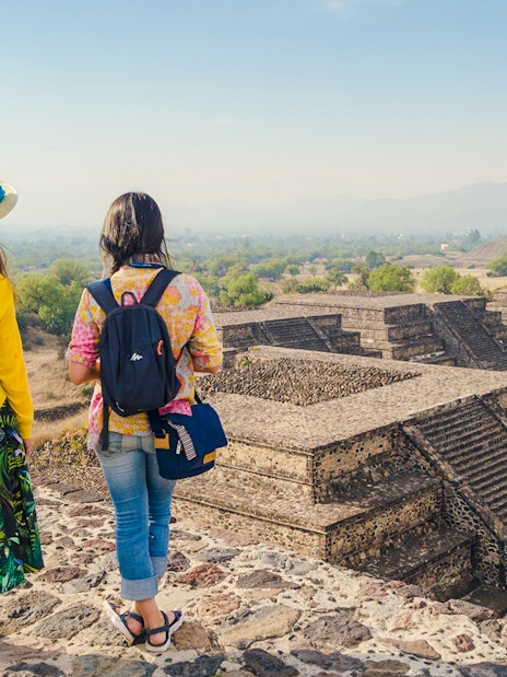 Two tourists overlooking the Teotihuacan pyramids during a guided walking tour.