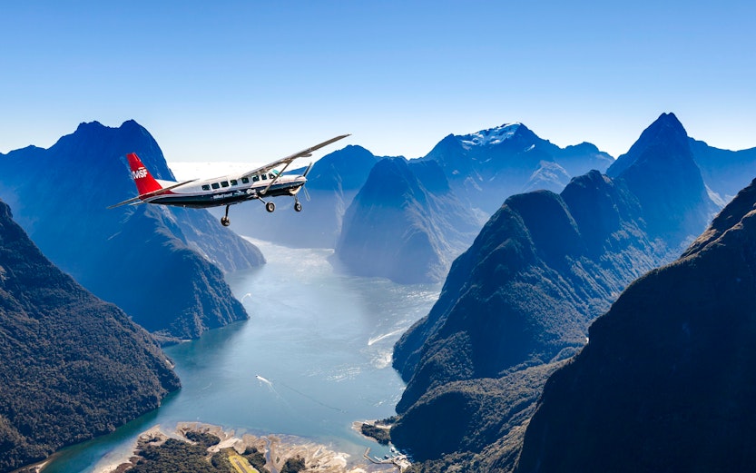 Aerial view of Milford Sound with cruise ship and plane, Queenstown flyover experience.