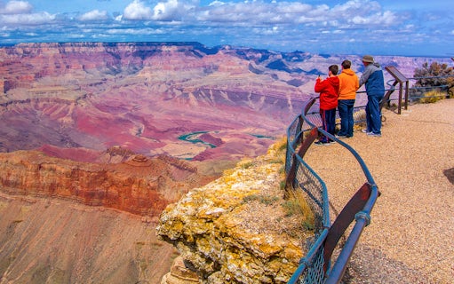 Visitors at Grand Canyon South Rim overlook vast canyon landscape.